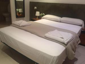 two beds in a hotel room with towels on them at Hostal Mont Thabor in Barcelona