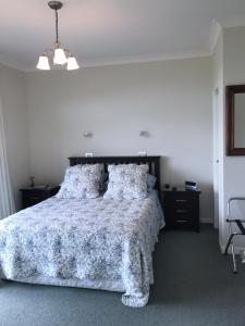 a bedroom with a bed with a blue and white comforter at Apartment 45 @ Noble Estate in Waikanae