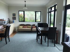 - un salon avec une table, des chaises et un canapé dans l'établissement Apartment 45 @ Noble Estate, à Waikanae