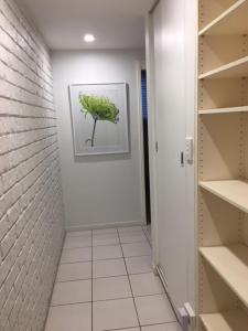 a door that is open to a room with a plant in it at Merrima Court Holidays in Caloundra