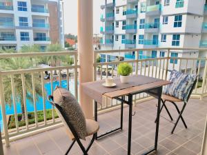 a table and chairs on a balcony with a view of the pool at Grandbeach Condo Unite A307 in Rayong