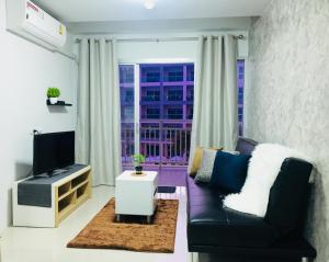 a living room with a couch and a tv at Grandbeach Condo Unite A307 in Rayong