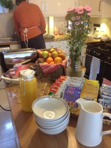 a table with a bowl of fruit and a basket of food at 2 Crescent Gardens Guest House in Bath