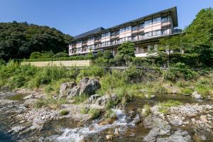 budynek obok rzeki z budynkiem w obiekcie Ichinomata Onsen Kanko Hotel w mieście Shimonoseki