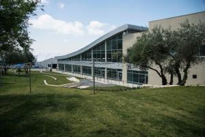 un grand bâtiment avec une pelouse devant lui dans l'établissement Ramat Rachel Resort, à Jérusalem