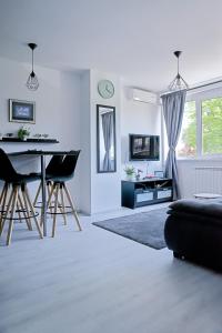 een witte woonkamer met een tafel en stoelen bij Drop (in) Apartment in Zagreb