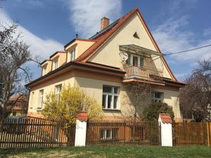 duży biały dom z drewnianym płotem w obiekcie Apartmán Nella w mieście Valtice