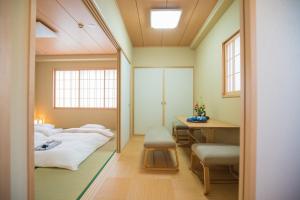 a room with two beds and a desk and a mirror at Hotel Yu-shu in Osaka