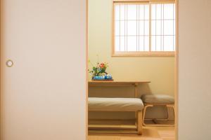 a room with a table and a bench and a window at Hotel Yu-shu in Osaka +16 photos