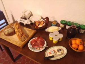 a table with bread and other food on it at Le Vin de l'Eté in Ponet-et-Saint-Auban