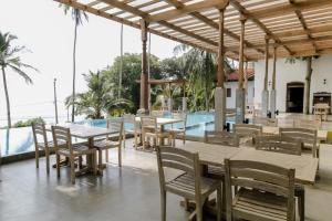 a restaurant with tables and chairs next to a pool at Nuga Eden Tangalle in Tangalle +37 photos