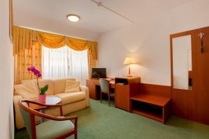 a living room with a couch and a desk with a computer at Hotel Zajazd Piastowski in Kazimierz Dolny