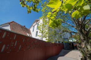 uma cerca em frente a um edifício com uma árvore em Der Ederer em Weiz