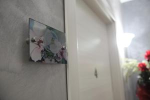 un cuadro colgado en una pared con un cuadro de flores en À La Maison De Gabry, en Vibo Valentia Marina