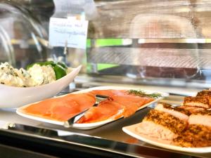 Eine Theke mit zwei Tellern Fisch und einer Schüssel Salat in der Unterkunft Hotel Weitblick Bielefeld in Bielefeld