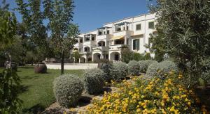 a building with a bunch of flowers in front of it at Garden Apartment Quinta do Morgado in Tavira