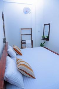 a bedroom with a large white bed with pillows at Yala Leisure Villa & Safari in Tissamaharama