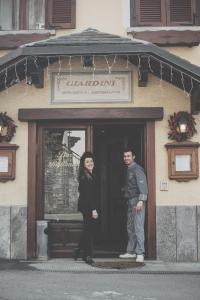 un hombre y una mujer parados frente a una puerta en Ristorante Residence Giardini, en Piode