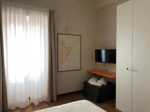 a room with a bed and a tv and a window at B&B Mare di Fuori in Stintino