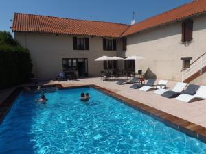 a group of people swimming in a swimming pool at Hôtel Le Baudiere & Spa in Saint-Beauzire