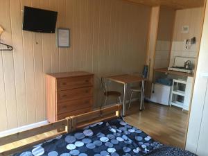 a room with a bedroom with a dresser and a kitchen at Orle Gniazdo domki in Stegna