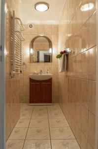 a bathroom with a sink and a mirror at Willa Róż in Międzyzdroje