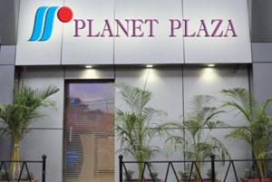 a sign for a planet plaza with plants in front of it at Hotel Planet Plaza in Mumbai