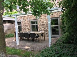 a table and chairs in front of a brick building at d'Uyterwaerde in Leut