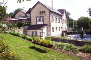 a bench sitting in the grass in front of a building at Moulin de Chappes in Chappes