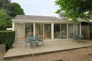 a conservatory with chairs and tables on a patio at Gite Mona & Lisa in Amboise