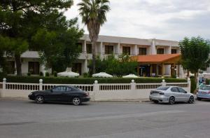 two cars parked in a parking lot in front of a building at Golden days in Afantou