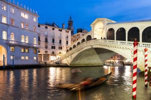 a gondola in the water in front of a bridge at San Polo Near Rialto Fish Market in Venice