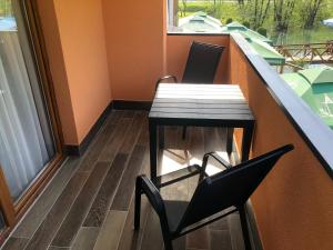 a table and chairs on a balcony with a window at Motel "KULA" in Cazin