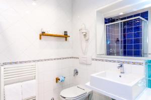 łazienka z umywalką, toaletą i oknem w obiekcie Hotel Rivoli Sorrento w Sorrento