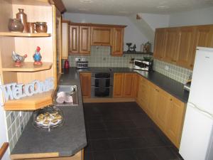 a kitchen with wooden cabinets and a plate of food on the counter at Nant-Y-Glyn in Llandrindod Wells