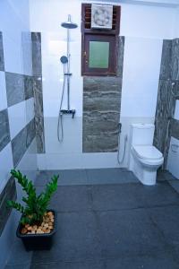 a bathroom with a toilet and a clock on the wall at Kottamba Yala Stay & Safari in Tissamaharama