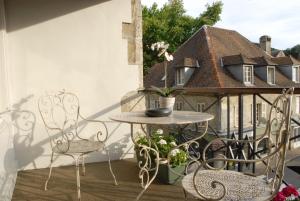 a patio with a table and chairs on a balcony at Hôtel de France in Ornans