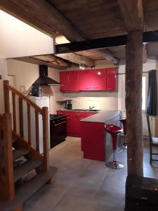 Mont-DolにあるL'ormelais vacancesの赤いキャビネットと階段が備わるキッチン