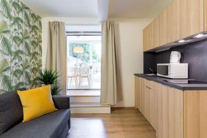 ein Wohnzimmer mit einem Sofa und einer Mikrowelle in der Unterkunft Cosy Green Oasis in city center in Zagreb
