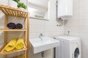 a bathroom with a sink and a washing machine at Cosy Green Oasis in city center in Zagreb
