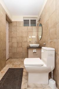 a bathroom with a white toilet and a sink at Locul Uptown - Near Bangalore Palace Grounds in Bangalore