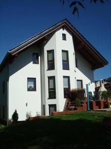 a white house with black windows at Ferienwohnung Michael Meißner ruhig, gemütlich und kinderfreundlich in Crottendorf