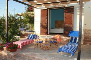 a patio with a table and chairs and a bed at LE VILLETTE di CALA MADONNA in Lampedusa