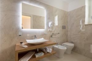 a bathroom with a sink and a toilet at Artemide Hotel in San Vito lo Capo