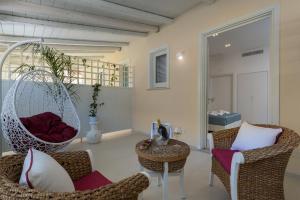 a living room with a swinging chair and a table at Artemide Hotel in San Vito lo Capo