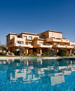 a building with a swimming pool in front of a building at Marbella Beach Resort at Club Playa Real in Marbella