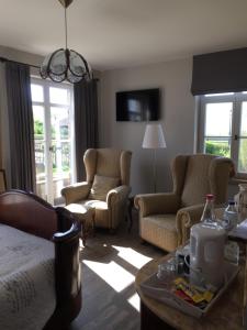 a living room with a bed and two chairs and a table at BB-hof ter boone in Kapelhoek