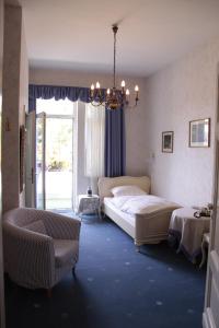 a bedroom with a large bed and a chandelier at Alte Villa Schlossblick in Bad Pyrmont