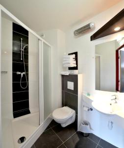 a bathroom with a toilet and a sink and a shower at The Originals City, Hôtel Pont Rouge (ex inter-hôtel), Carcassonne in Carcassonne