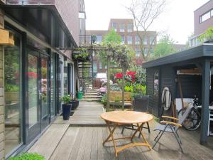 a wooden deck with a table and chairs on a building at M&M Bed&Bubbles in Amsterdam